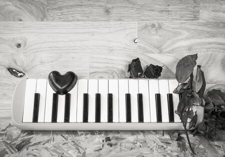 Still life with black heart and melodion on wooden backgroundの写真素材