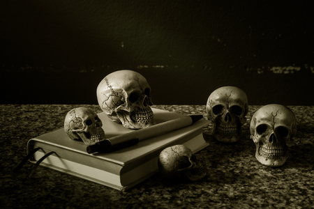 Still life with human skull and notebook on grunge backgroundの写真素材