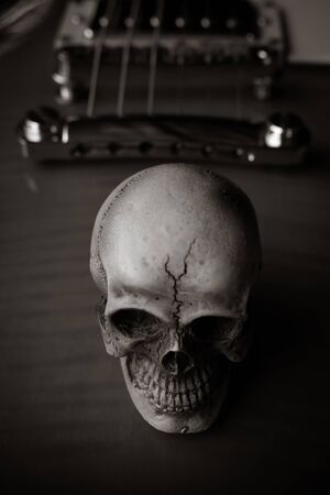 Still life with human skull on guitar background