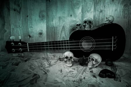 Still life with skull and old ukulele on wooden backgroundの写真素材