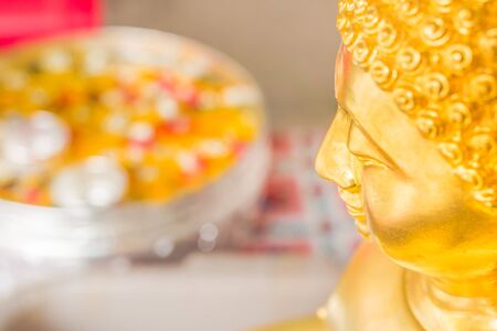 Buddha statue and bowl of water and flowers for Songkran festival in Thailandの写真素材