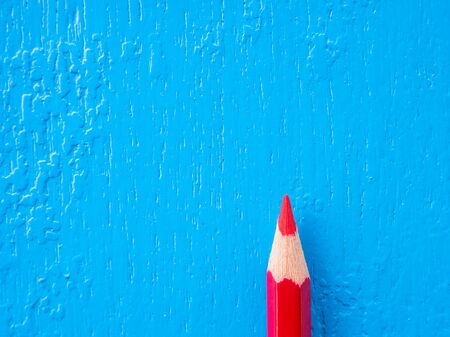 Red colorful pencil on  blue wooden backgroundの写真素材