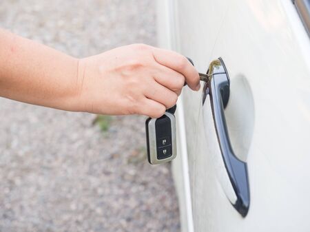 Woman open door lock with key and electronic remote