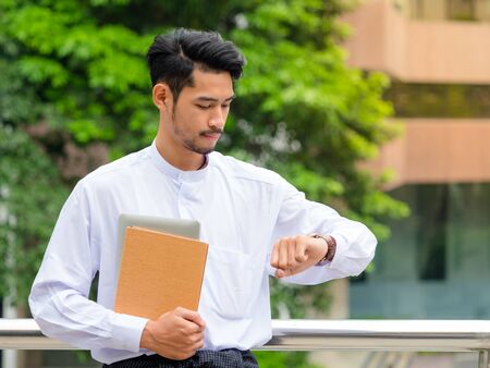 Young Burmese businessman watches the watch ,It's time to talk about businessの写真素材