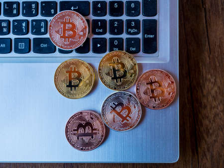 Bitcoins are copper, gold and silver, which are in the digital currency. On a keyboard backgroundの写真素材