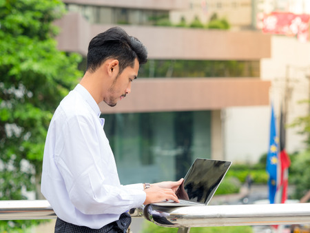 Young Burmese businessman find data in laptop ,It's time to talk about businessの写真素材