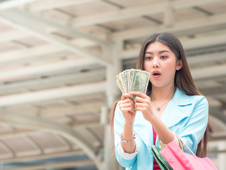 Beautiful asian woman are excited after get money to go shoppingの写真素材