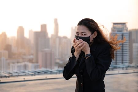Asian business women have to use a mask to cover the face to prevent pollution from dust, And prevent infection from viruses that are spreading in the airの写真素材