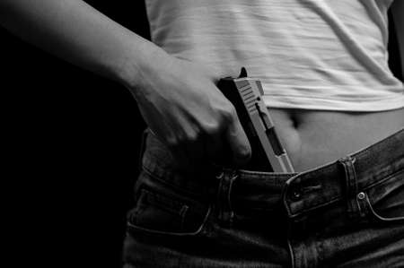 Young women who are stressed from using drugs, Carrying a gun, ready to use violence to commit crimes related to drug dealingの写真素材