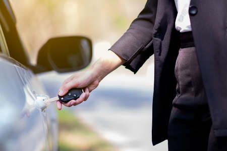 Business woman open door lock with key and electronic remoteの写真素材