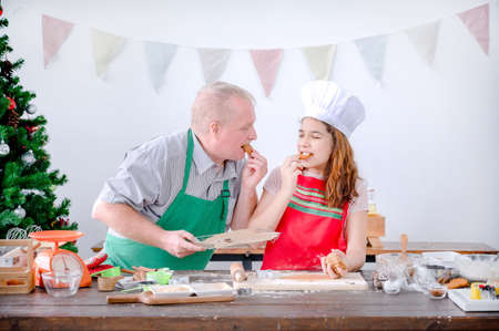 A young European girl and her father tests out the gingerbread she does during Christmas and New...
