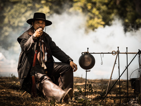 A senior cowboy sat with a gun to guard the safety of the camp in the western area