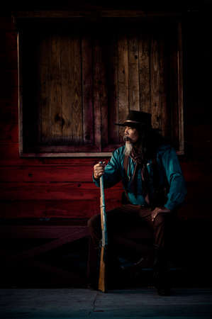 The senior cowboy is aiming the rifle at the attacker, While security surveillance in rural farm...