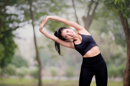 A beautiful Asian woman is warm up, To make the muscles flexible Before going to jogging for good...
