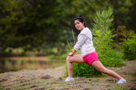 A beautiful Asian woman is warm up, To make the muscles flexible Before going to jogging for good...