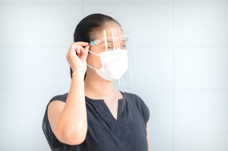 Women have to use masks and face shields to protect against pollution from dust and infections from secretions that spread in the air, during the outbreak of the corona virus throughout the worldの写真素材