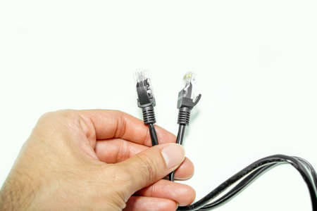 Hand holding black internet cables.