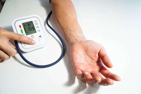 Men's health check blood pressure.and heart rate with digital pressure gauge standard blood pressure test results .Health and Medical conceptの写真素材