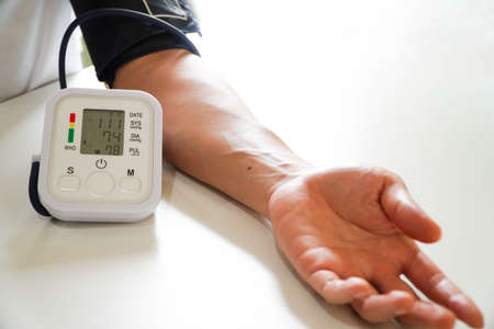 Middle-aged male patients with bp, heart rate, digital pulse monitoring device for elderly medical awareness in ischemic hypertension, hypertension and cardiovascular disease. In elderly womenの写真素材