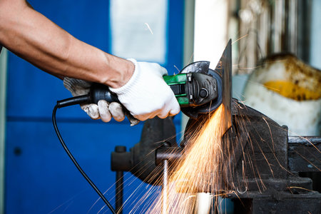 Electric iron grinding machine in factory Sparks from grinding wheelsの写真素材