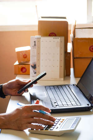 Close up of man busy paying bills online on computer calculating household finances or taxes on machine, female manage home family expenditures, using calculator, make payment on laptopの写真素材