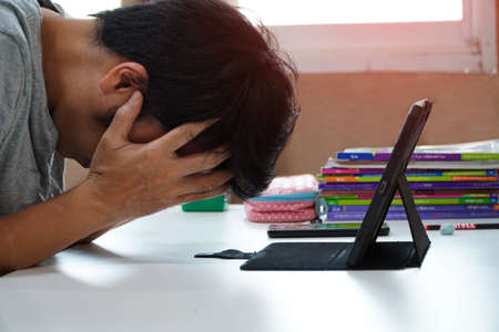 Asian men with headaches from work at home, man feeling tiredの写真素材