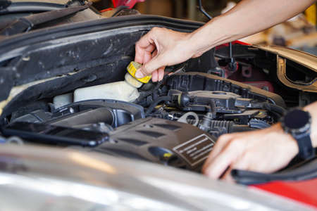 Asian technicians inspect brake fluid for engine compartment care and basic service concept of the vehicle and braking system.の写真素材