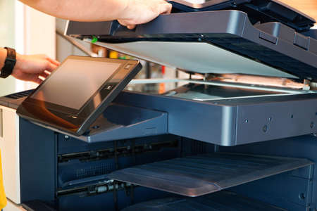 Men press the button of the copier. Man copying paper from Photocopier. Men use printing machines. man using photocopierの写真素材