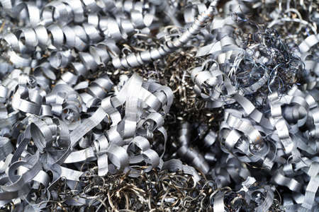 Steel scrap materials recycling. Aluminum chip waste after machining metal parts on a cnc lathe. Closeup twisted spiral steel shavings. Small roughness sharpness,の写真素材
