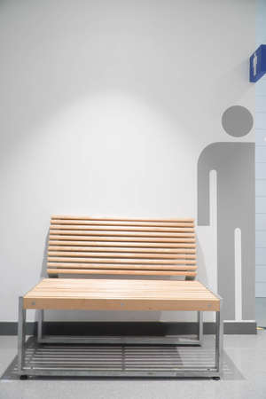 Slatted chair in front of the men's bathroomの写真素材