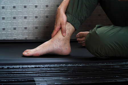 Asian man hurts his ankle while running on a treadmill,concept of not wearing shoes while running on a treadmillの写真素材