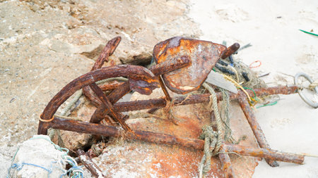 Rusty old anchor on the sandy beachの写真素材