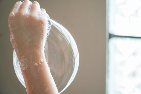 Asian girls play with soap bubbles in the bathroom.