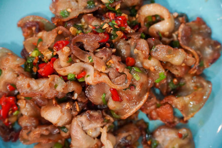 Stir fried chili and salt pork with Thai herbs in a black bowl, Asian cuisine