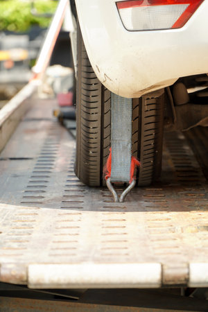 Car tire secured with belt for safety on flatbed tow truck,Securing the load of a car transporter,の写真素材