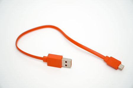USB charging cable for smartphone orange on white backgroundの写真素材