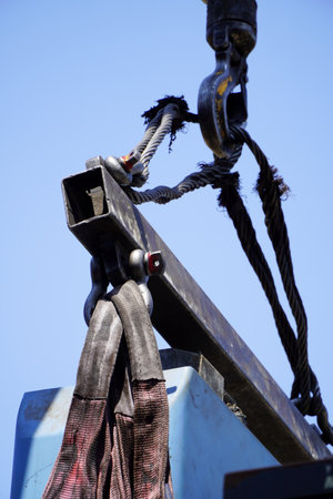 Crane boom with isolated hook, blue sky background,Elements of crane: hook, loop, chain, connecting...