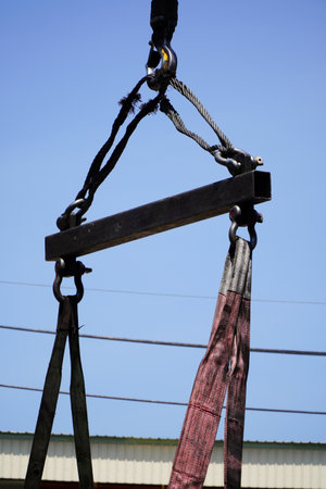 Crane boom with isolated hook, blue sky background,Elements of crane: hook, loop, chain, connecting...
