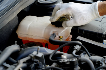 Car coolant level in radiator system in car,mechanic inspects the expansion tank with pink antifreeze, automotive part.の写真素材
