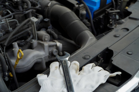 Wrench lies with white glove on car engine in garage,Repair service. authentic close-up shotの写真素材