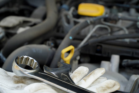 Wrench lies with white glove on car engine in garage,Repair service. authentic close-up shotの写真素材