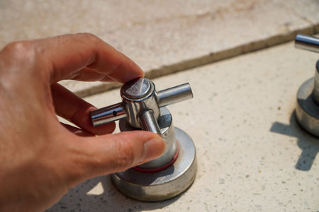 Handsome young man opening the faucet in the bathtub,chrome faucet external bathroom