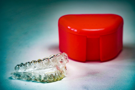 Invisalign invisible braces and red plastic box on a white background.teeth whitening conceptの写真素材
