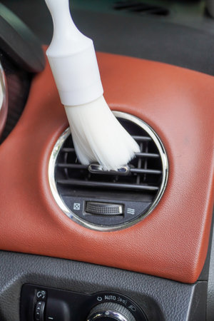 car cleaning staff,soft white brush cleans and removes dust from car air vents.car detailing (or valeting) concept.の写真素材