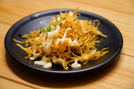 Crispy noodles and mayonnaise on wooden table in restaurant