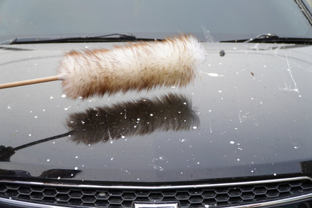 Man holding a Merino Wool Duster a dusty black car