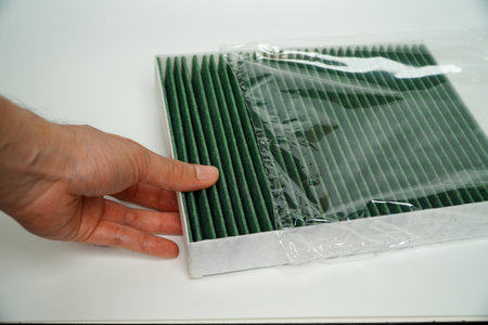 Car air filter in plastic bag, close-up of male hand,Car cabin air filter. Car air cleaning spare parts. cabin air filter , car air filter on white backgroundの写真素材