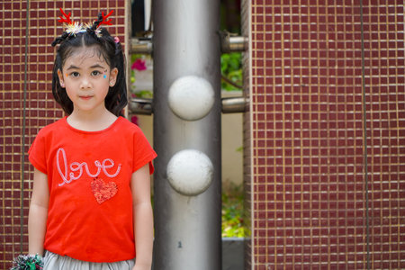Unidentified asian little girl wearing red t-shirt and blue skirt.の写真素材