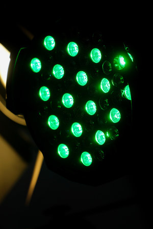 Green led spotlights on a black background. Close-up, Stage lights and smoke stage during concert. Several projectors in dark on the rampの写真素材