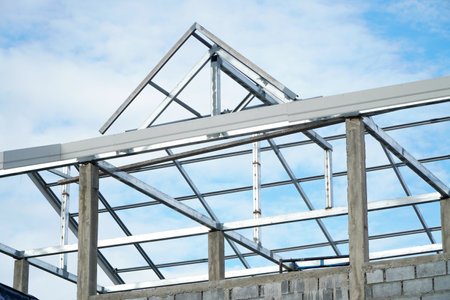 Roof structure of a new house under construction with blue sky.